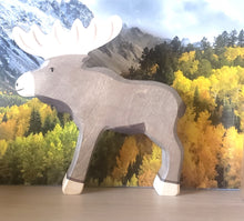 Gray moose figure with a mountain and forest background